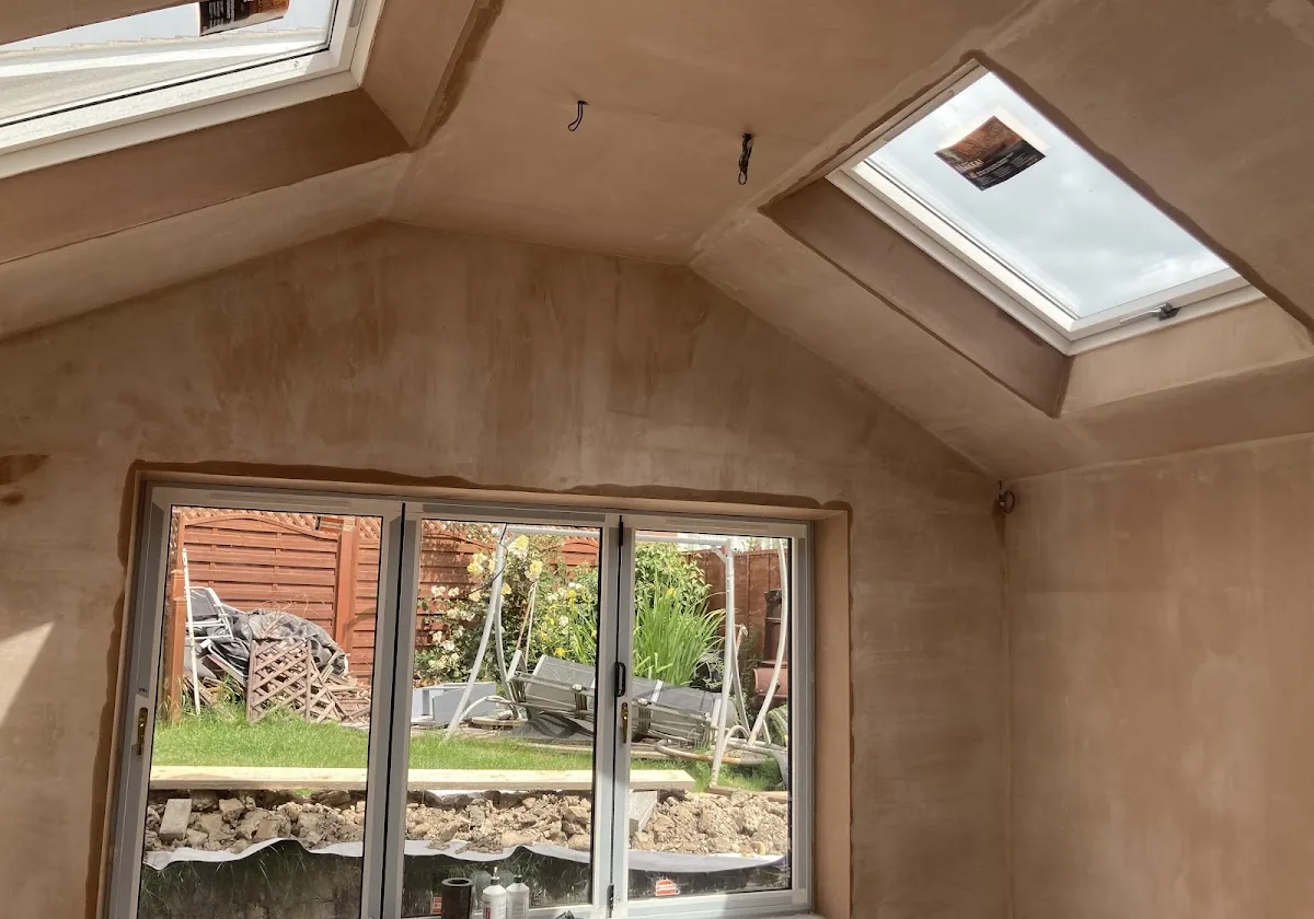 Rear extension skimmed throughout, pitched ceiling and walls finished around a Velux window and patio doors