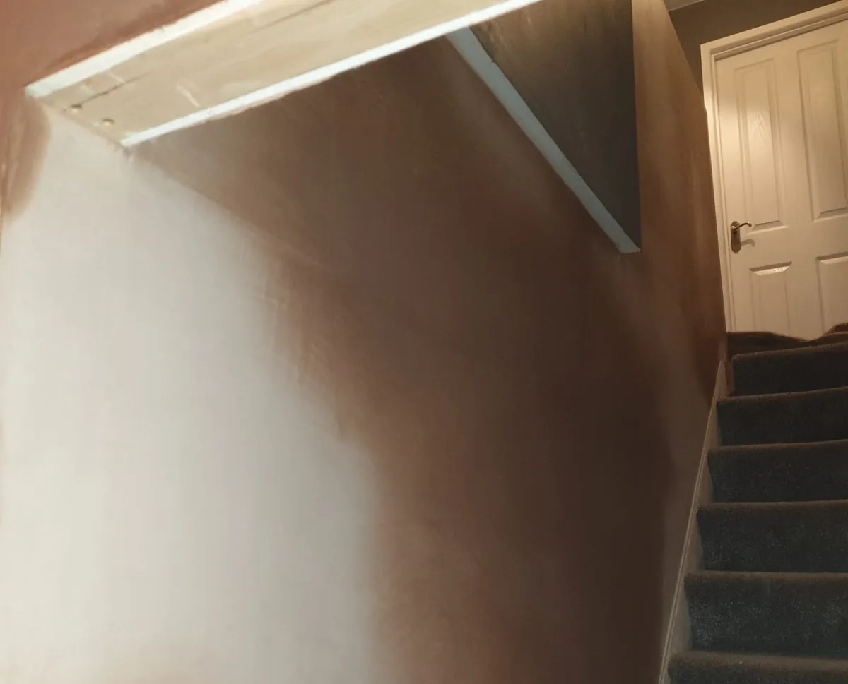 Stairwell wall and sloped ceiling skimmed smooth above a staircase